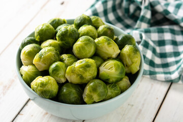 Set of brussel sprouts in a  bowl on white wooden table