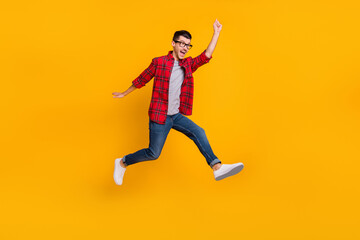 Full size profile side photo of young happy excited funky man in glasses running fast in air isolated on yellow color background
