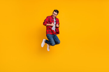 Fototapeta na wymiar Full size photo of young happy excited smiling positive man in glasses jump show thumb-up isolated on yellow color background