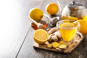 Ginger tea with lemon and honey in crystal glass on wooden table.Copy space	