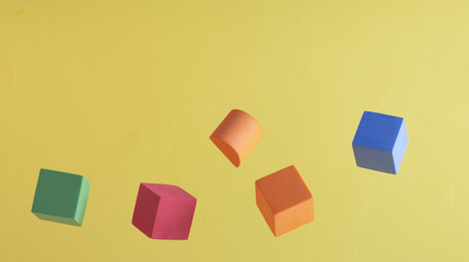Fototapeta na wymiar Colorful cubes on a yellow background
