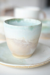 Turquoise handmade cups. Kitchen tea set on a white table. Minimalistic set of dishes