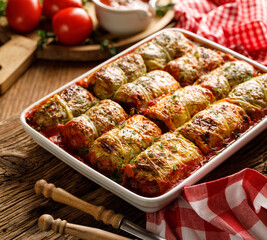 Stuffed  cabbage, cabbage rolls with vegetarian filling in tomato sauce in a casserole dish, close up view
