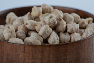 Heap of raw white peas in wooden bowl