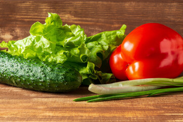 Set for making salad of fresh herbs, cucumbers and red pepper on a vintage table