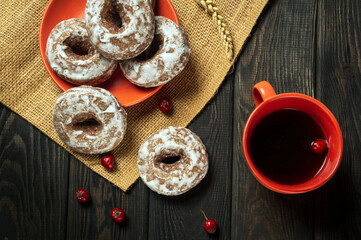 Homemade round gingerbread cookies with icing in a plate and hot rosehip tea. Idea for a delicious breakfast or dinner. Top view