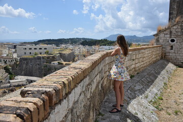 woman standing on a stone wall