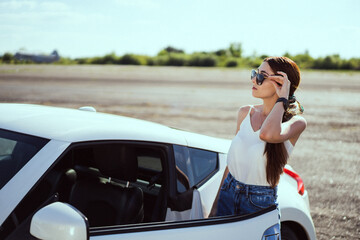 Beautiful girl in sunglasses near car