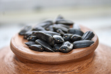 Unpeeled sunflower seeds in bowl isolated on white background. Top view.