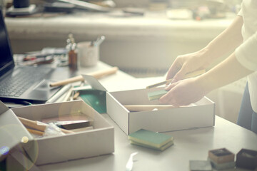 unrecognizable woman takes apart a ready-made set for creativity. a woman wants to make jewelry on her own according to video tutorials