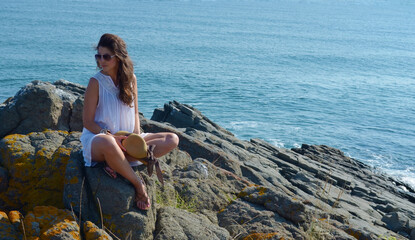 Young Woman Sitting on a Rocks   Above the Sea 