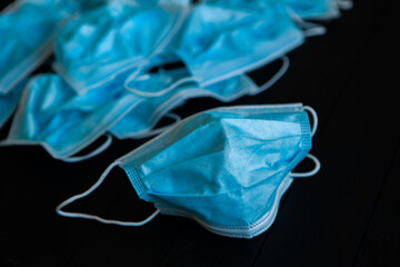 Fototapeta premium Used blue surgical protective masks. Pollution by surgical masks during the coronavirus pandemic. Covid-19 plastic waste and garbage, disposable masks.