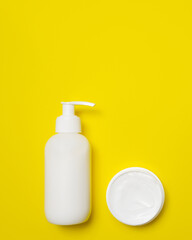 Fototapeta na wymiar Jar and box of cream on a yellow background.