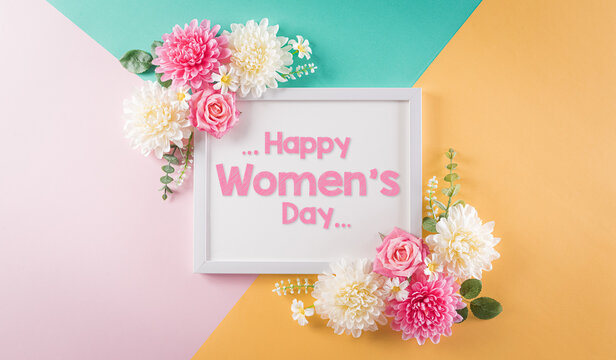 Happy women's day concept, beautiful flower with picture frame and Happy Women's Day text on pastel background. Flat lay ,top.
