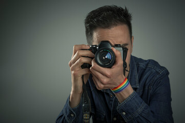 young man with rainbow bracelet taking a picture with camera