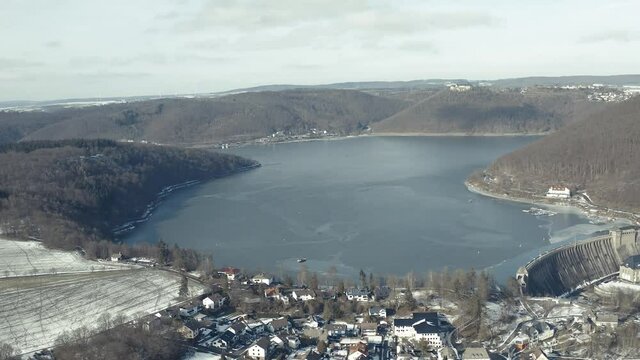 Drone Aerial views of the Keller National Park in Winter. The barrier lake Edersee is partly frozen. The Ederstausee is located in Hesse near the town Waldeck in Germany, Europe.