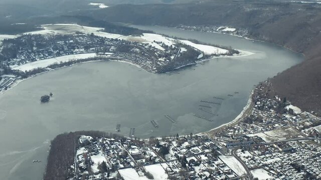 Drone Aerial views of the Keller National Park in Winter. The barrier lake Edersee is partly frozen. The Ederstausee is located in Hesse near the town Waldeck in Germany, Europe.