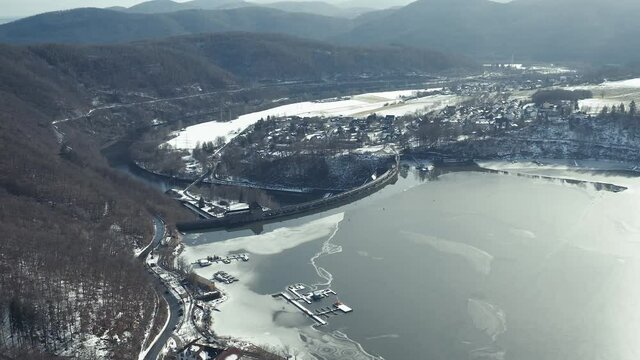 Drone Aerial views of the Keller National Park in Winter. The barrier lake Edersee is partly frozen. The Ederstausee is located in Hesse near the town Waldeck, Germany.