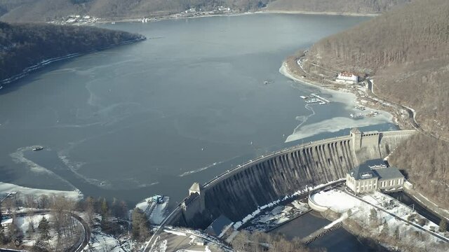 Drone Aerial views of the Keller National Park in Winter. The barrier lake Edersee is partly frozen. The Ederstausee is located in Hesse near the town Waldeck in Germany, Europe.