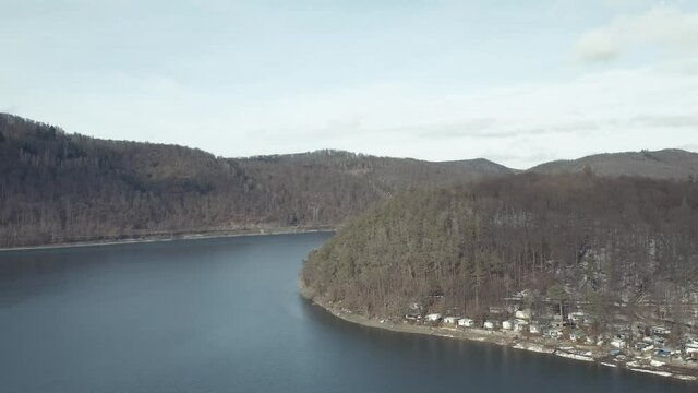 Drone Aerial views of the Keller National Park in Winter. The barrier lake Edersee is partly frozen. The Ederstausee is located in Hesse near the town Waldeck in Germany, Europe.