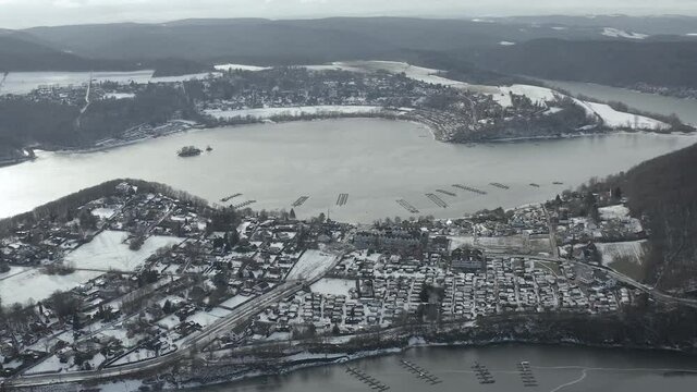 Drone Aerial views of the Keller National Park in Winter. The barrier lake Edersee is partly frozen. The Ederstausee is located in Hesse near the town Waldeck in Germany, Europe.