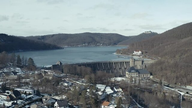 Drone Aerial views of the Keller National Park in Winter. The barrier lake Edersee is partly frozen. The Ederstausee is located in Hesse near the town Waldeck in Germany, Europe.