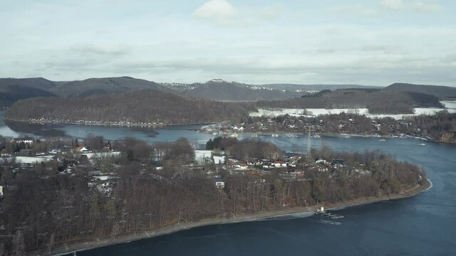 Drone Aerial views of the Keller National Park in Winter. The barrier lake Edersee is partly frozen. The Ederstausee is located in Hesse near the town Waldeck in Germany, Europe.
