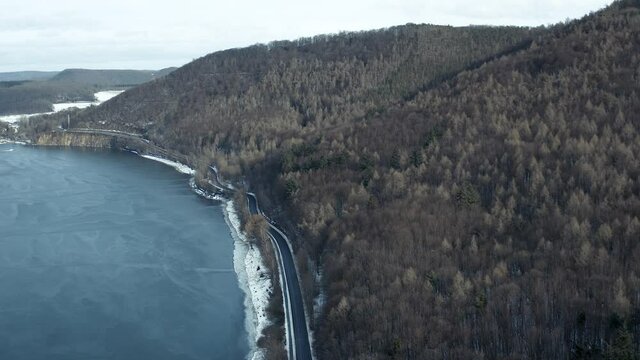 Drone Aerial views of the Keller National Park in Winter. The barrier lake Edersee is partly frozen. The Ederstausee is located in Hesse near the town Waldeck in Germany, Europe.