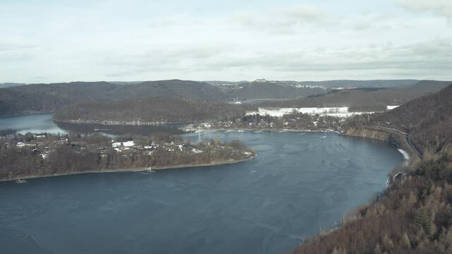 Drone Aerial views of the Keller National Park in Winter. The barrier lake Edersee is partly frozen. The Ederstausee is located in Hesse near the town Waldeck in Germany, Europe.