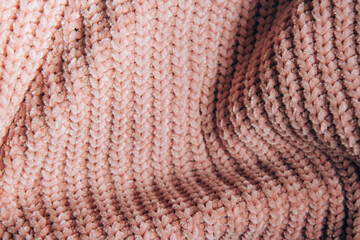 The beautiful texture of the knitted fabric. Knitted nude pink fabric as background. Copy space