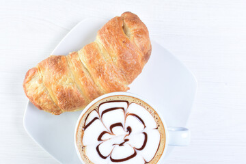 Cup of Colombian coffee, accompanied by baked bakery on white wooden background