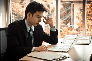 Smart asian businessman working with laptop at office.