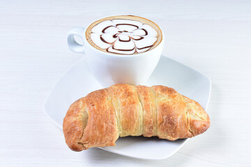 Cup of Colombian coffee, accompanied by baked bakery on white wooden background