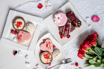 Fototapeta na wymiar beautiful tasty romantic selection of pink chocolate love heart shape cakes for wedding, mothers day, valentines day, spring flower biscuits tartlet and rose petals 