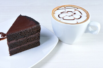 Cup of Colombian coffee, accompanied by baked cake on white wooden background
