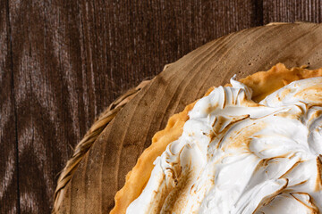 Lemon pie on top of log and wooden table. zenithal view
