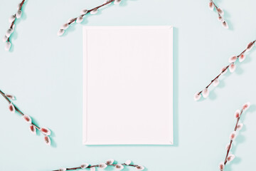 Spring flower composition. Photo frame, willow twigs on mint background. Flat lay, top view, copy space