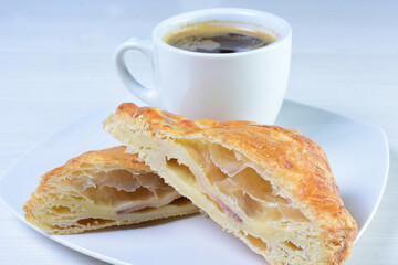 Cup of Colombian coffee, accompanied by baked bakery on white wooden background