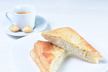 Cup of Colombian coffee, accompanied by baked bakery on white wooden background