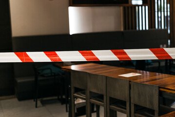 Closed due to pandemic. Premises of cafe are covered with red and white ribbon. Concept of closing public places