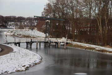 Fototapeta na wymiar Snow on the meadows with bridge over the ring canal Zuidplaspolder