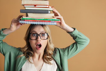 Shocked beautiful woman posing with books and planners on her head
