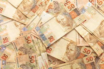 Money from Brazil. Notes of Real, Brazilian currency. Hundred reais notes, background use red. Concept of economy, inflation and business. 