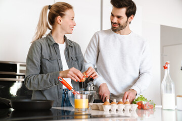 Attractive young couple cooking breakfast at the kitchen