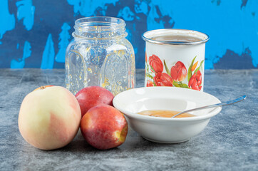 Fototapeta na wymiar Peaches, jam and cup of tea on marble table