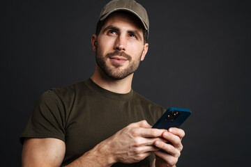 Confident young happy man holding mobile phone