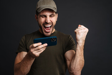 Confident young happy man holding mobile phone