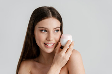 Happy shirtless nice girl smiling while posing with facial cream