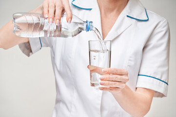 Healthy eating or lifestyle concept - female woman doctor holding and a glass of clear fresh water