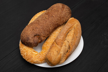 Different types of bread on a black background.